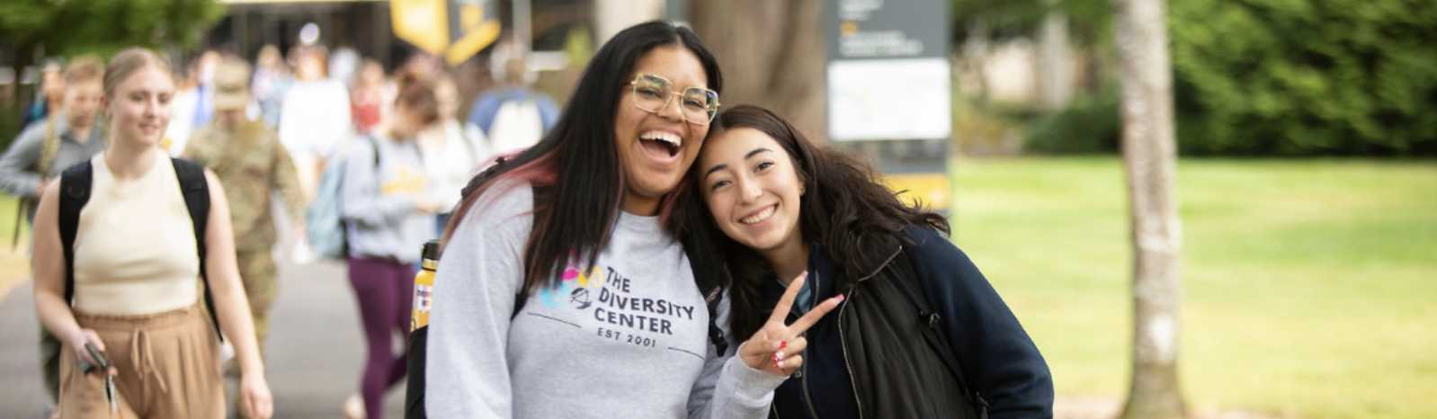 Two students smiling for camera, huddled close